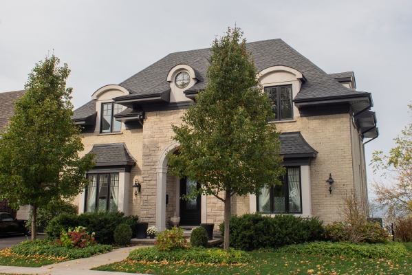 Designs by Santy :: Lakeside Retreat Front exterior with stone, and round dormers