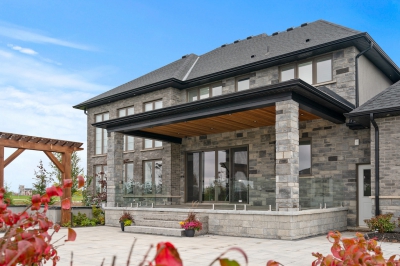 Designs by Santy :: Grand Estate Rear exterior with stone, covered patio and glass rail