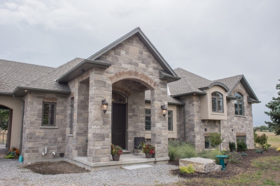 Designs by Santy :: Grand Reno Front exterior with stone, stucco, and arched dormers