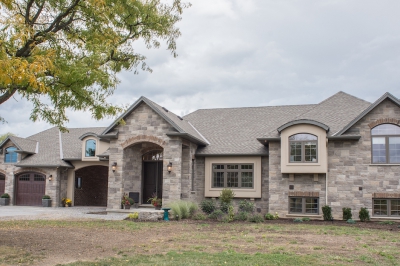 Designs by Santy :: Grand Reno Front exterior with stone, stucco, and arched dormers