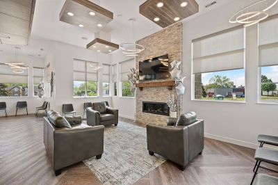 Designs by Santy :: Prairie Smiles Waiting room with fireplace, wood floor, and chandeliers