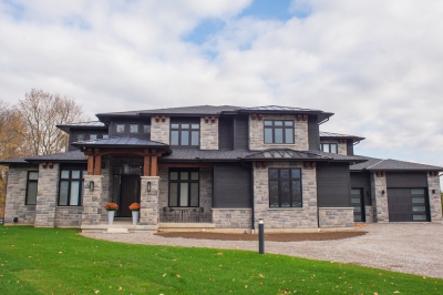 Designs by Santy :: Regal Prairie Estate Front exterior with stone, black siding, and timber accents