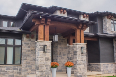 Designs by Santy :: Regal Prairie Estate Front exterior with stone, black siding, and timber accents